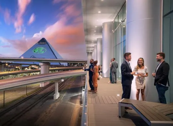 Renasant Convention Center, guests on the balcony at sunset with the Pyramid beyond